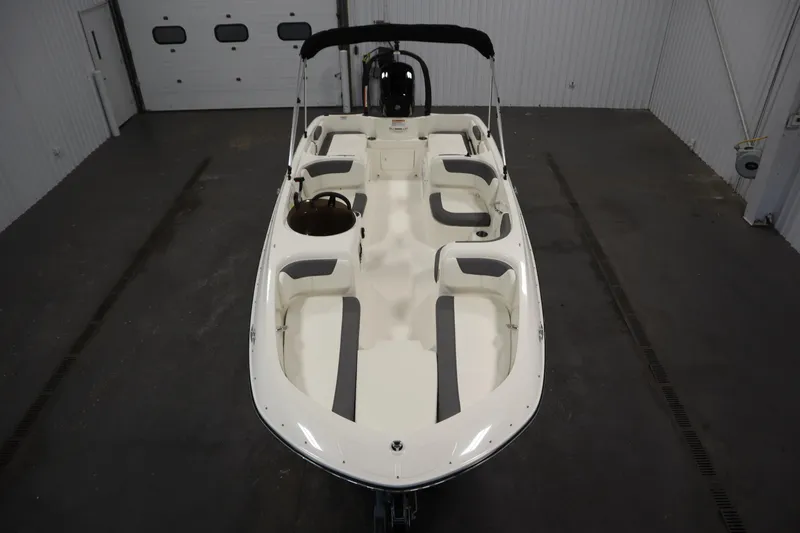 Slide: The Image of 2022 Bayliner E18 Element boat in a garage, showcasing spacious seating and sleek design. - 9