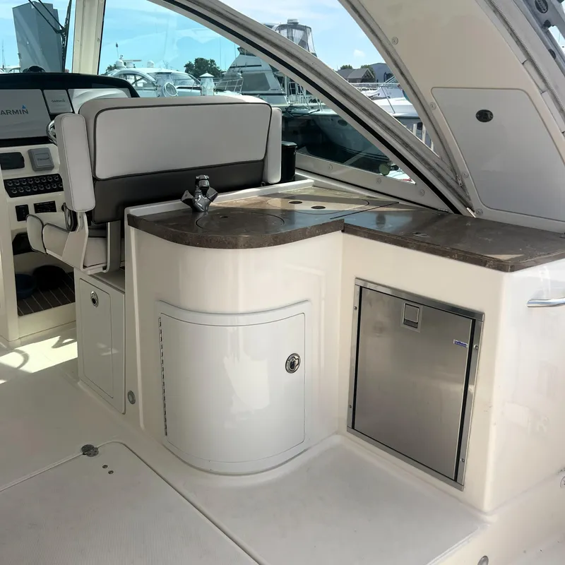 Slide: The Image of 2016 World Cat 320 DC boat interior with helm, sink, and storage. - 19