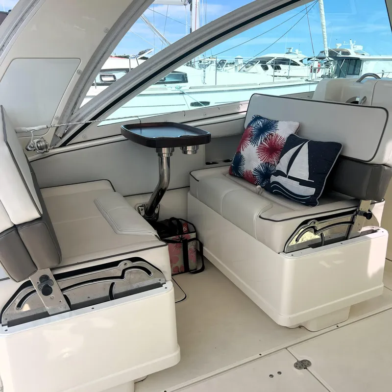 Slide: The Image of Interior of a 2016 World Cat 320 DC boat with cushioned seating and decorative pillows. - 21