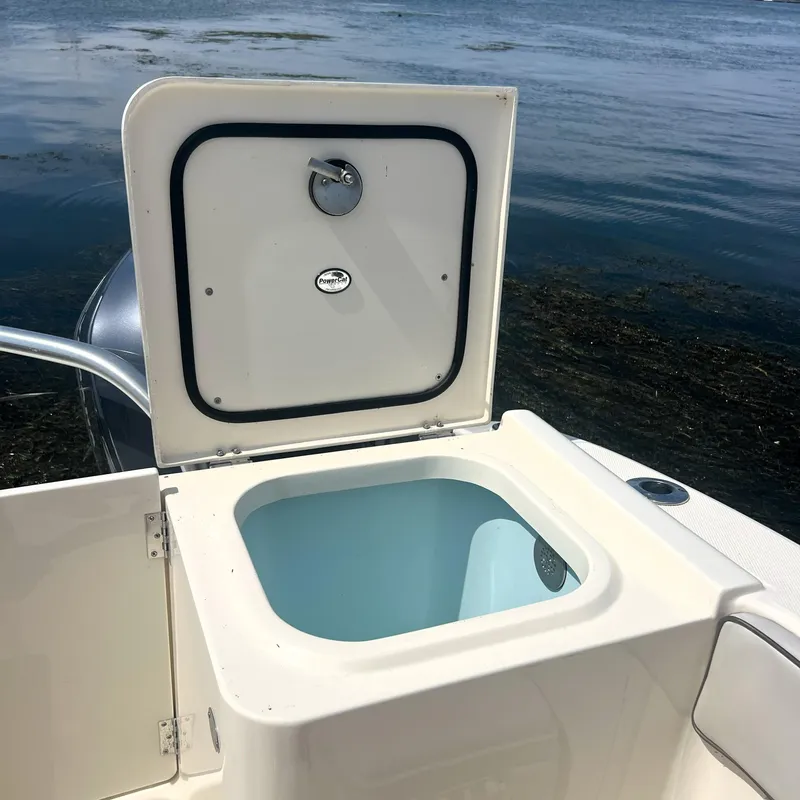Slide: The Image of Open storage compartment on 2016 World Cat 320 DC boat by the water. - 26
