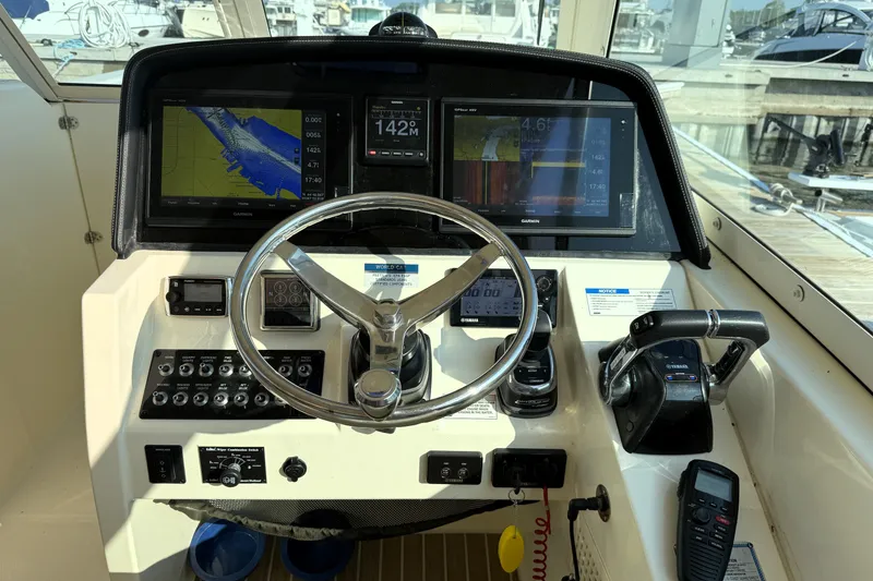 Slide: The Image of Control panel of a 2016 World Cat 320 DC boat with navigation screens and steering wheel. - 31
