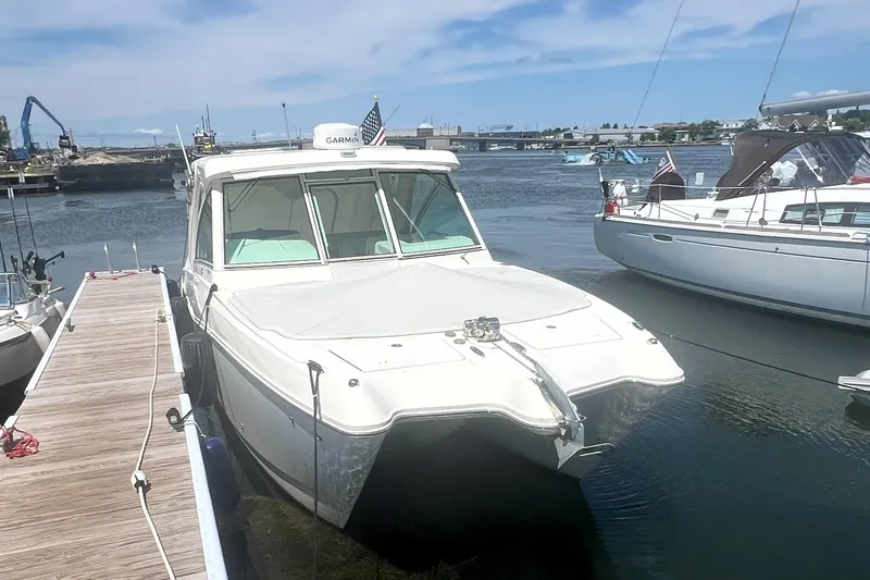 Slide: The Image of 2016 World Cat 320 DC boat docked in a marina under a clear sky. - 6
