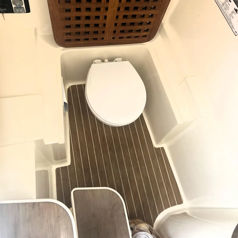 Slide: The Image of 2016 World Cat 320 DC boat interior with toilet and wooden flooring. - 9