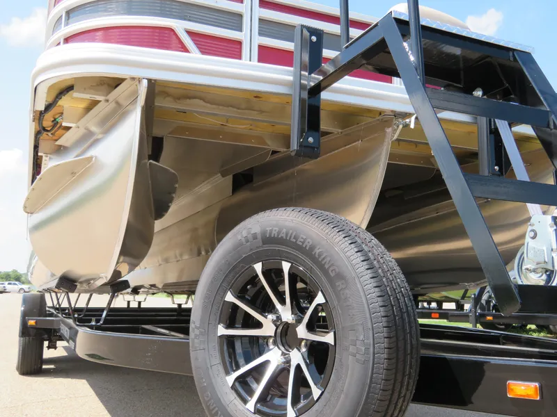 Slide: The Image of 2024 Bennington 22 SSR pontoon boat on trailer, showcasing undercarriage and wheel detail. - 3