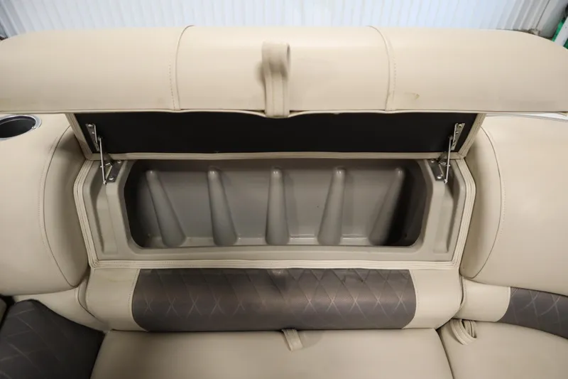 Slide: The Image of 2022 Tracker 20 Party Barge DLX storage compartment with beige cushioned seating. - 13