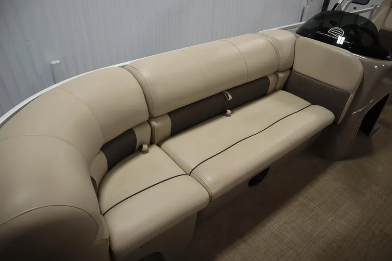 Slide: The Image of 2022 Tracker 20 Party Barge DLX boat interior with beige seating and console. - 16