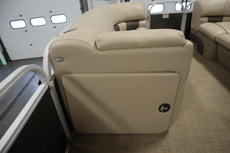 Slide: The Image of 2022 Tracker 20 Party Barge DLX interior with beige seating and storage compartment. - 20