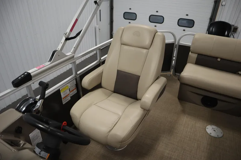 Slide: The Image of 2022 Tracker 20 Party Barge DLX interior with beige captain's chair and steering wheel. - 34
