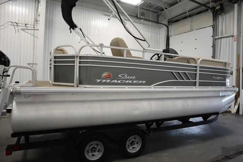 Slide: The Image of 2022 Tracker 20 Party Barge DLX pontoon boat in indoor storage facility. - 4