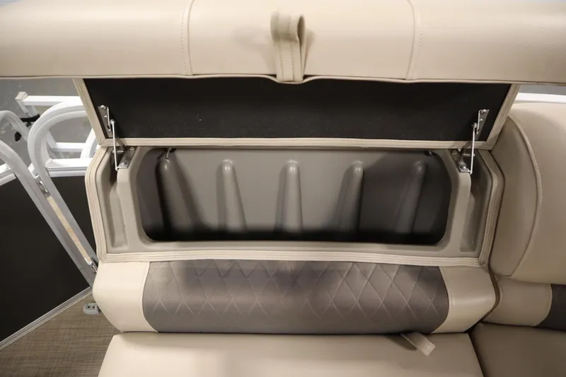 Slide: The Image of 2022 Tracker 20 Party Barge DLX seat storage compartment open, showcasing interior space. - 43