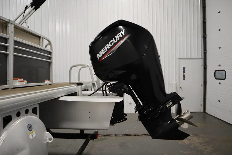 Slide: The Image of 2022 Tracker 20 Party Barge DLX with Mercury outboard motor in a garage setting. - 45