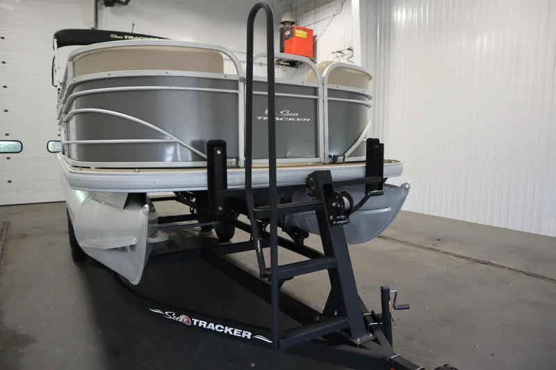 Slide: The Image of 2022 Tracker 20 Party Barge DLX pontoon boat on trailer in indoor storage. - 48