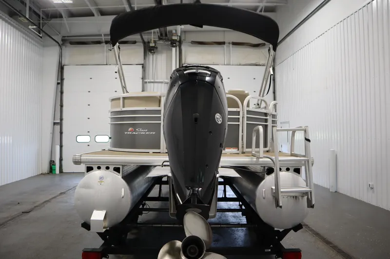 Slide: The Image of 2022 Tracker 20 Party Barge DLX pontoon boat in indoor storage facility. - 6