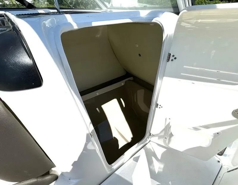 Slide: The Image of 2013 Yamaha Boats 242 Limited S storage compartment, open and empty, with white and beige interior. - 30