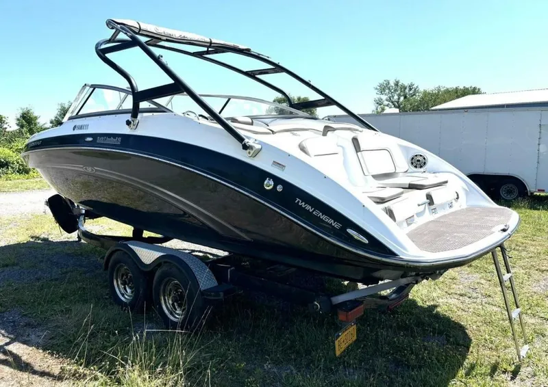 Slide: The Image of 2013 Yamaha Boats 242 Limited S on trailer, parked outdoors, showcasing sleek design and twin engines. - 3