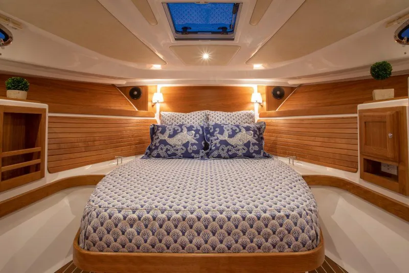 Slide: The Image of Luxurious cabin interior of 2026 Back Cove 34O with elegant bedding and wooden accents. - 9