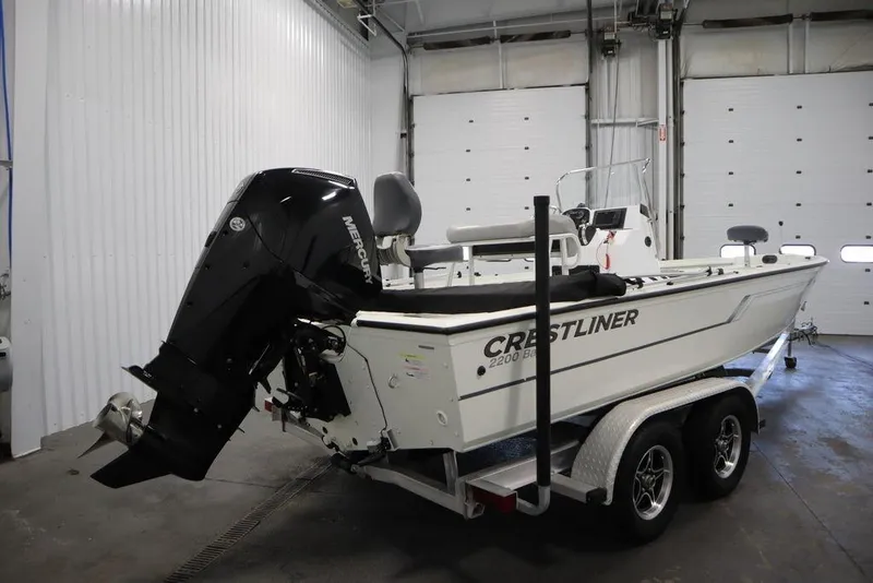 Slide: The Image of A Crestliner 2200 Bay boat with Mercury engine on a trailer in a garage. - 3