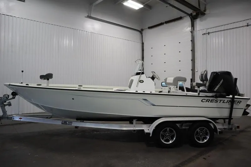 Slide: The Image of A Crestliner boat on a trailer in a garage, featuring a Mercury engine. - 5