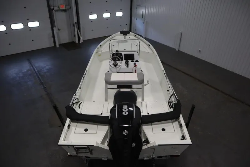 Slide: The Image of 2020 Sun Tracker Party Barge 20 DLX in a garage, showcasing interior and motor. - 6