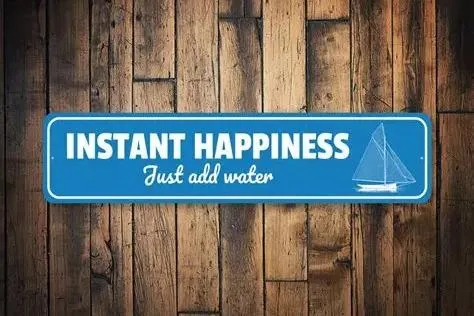 Slide: The Image of Blue sign on wooden background with sailboat, reads "Instant Happiness, Just Add Water." Avalon Catalina Entertainer 2024. - 19