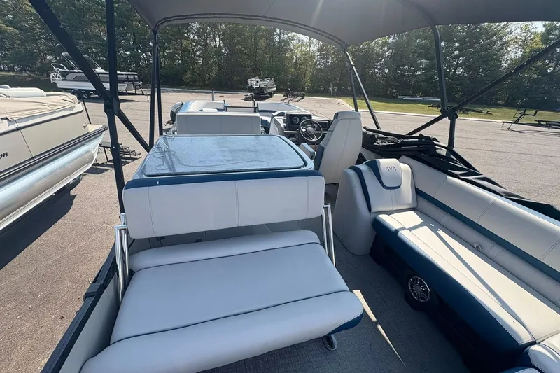 Slide: The Image of 2024 Avalon Catalina Entertainer boat interior with seating and steering wheel, parked outdoors. - 21