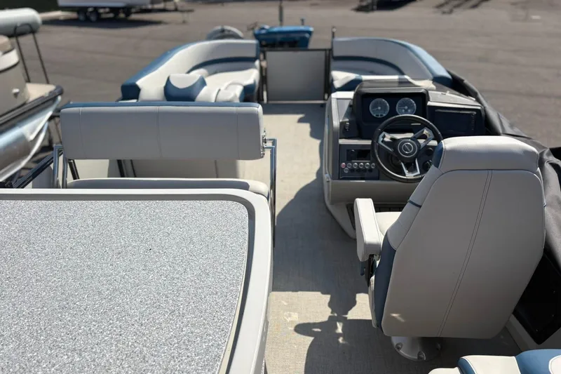 Slide: The Image of 2024 Avalon Catalina Entertainer boat interior with steering console and seating area. - 22