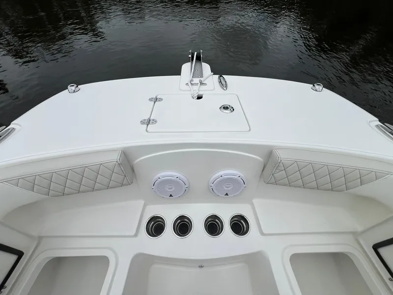 Slide: The Image of 2025 World Cat 230 DC boat interior with cushioned seating and speaker system. - 10