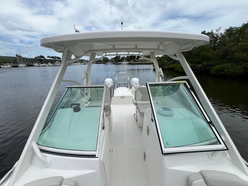 Slide: The Image of 2025 World Cat 230 DC boat on calm water, featuring sleek design and spacious seating. - 11