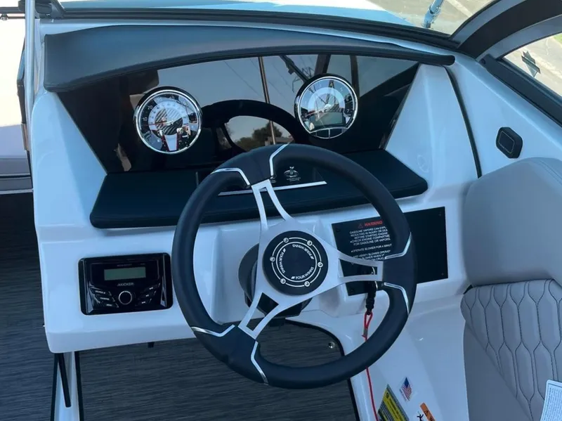 Slide: The Image of 2023 Four Winns H1 boat dashboard with steering wheel and gauges. - 16
