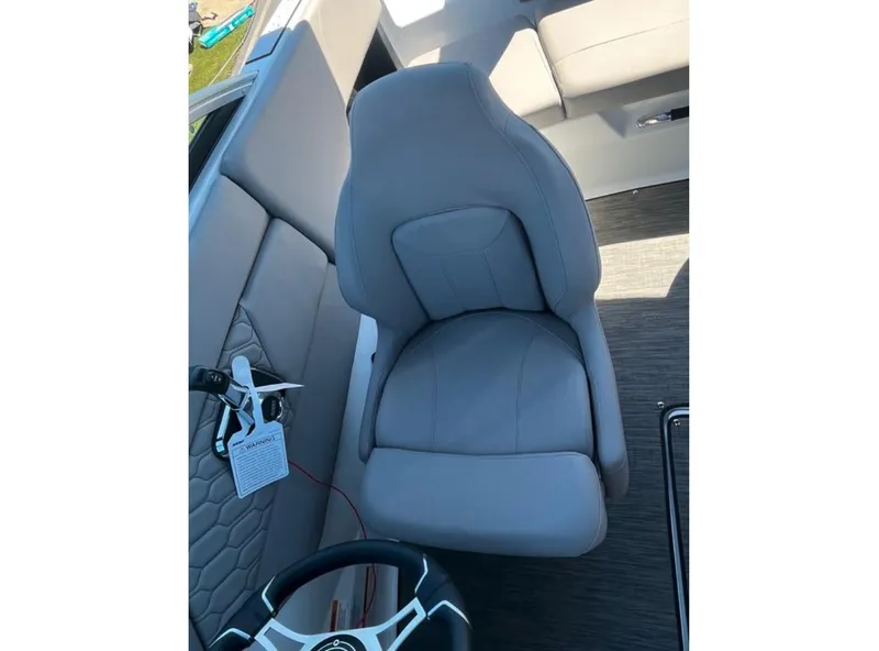 Slide: The Image of 2023 Four Winns H1 boat interior with gray captain's seat and steering wheel. - 19