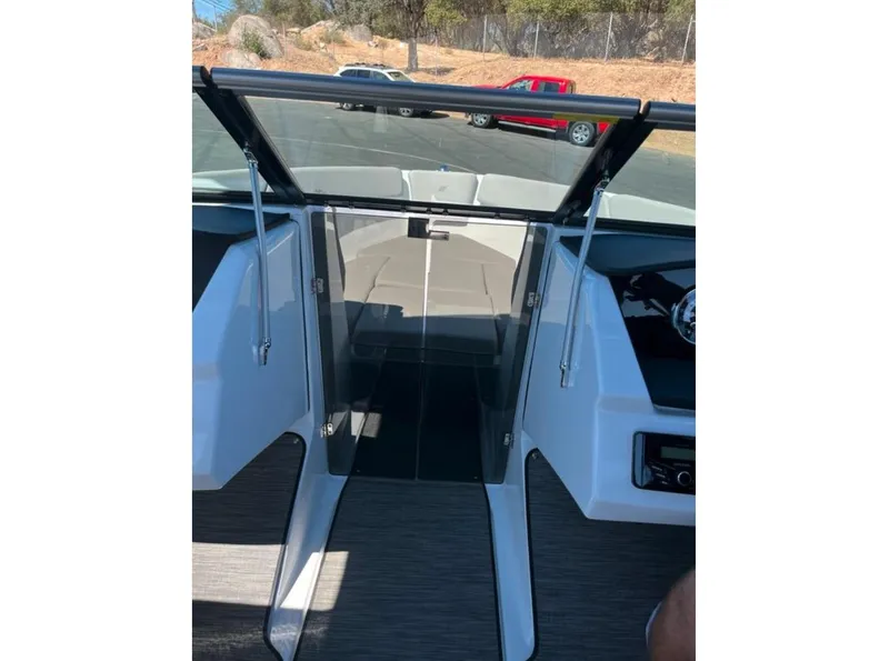 Slide: The Image of 2023 Four Winns H1 boat interior with open windshield and dashboard view. - 27