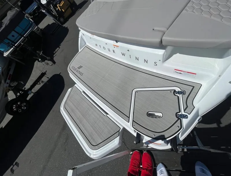 Slide: The Image of 2023 Four Winns H1 boat deck with gray flooring and logo. - 6