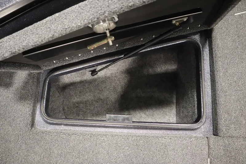 Slide: The Image of 2023 Lund 189 PRO V boat storage compartment with secure latch and carpeted interior. - 19