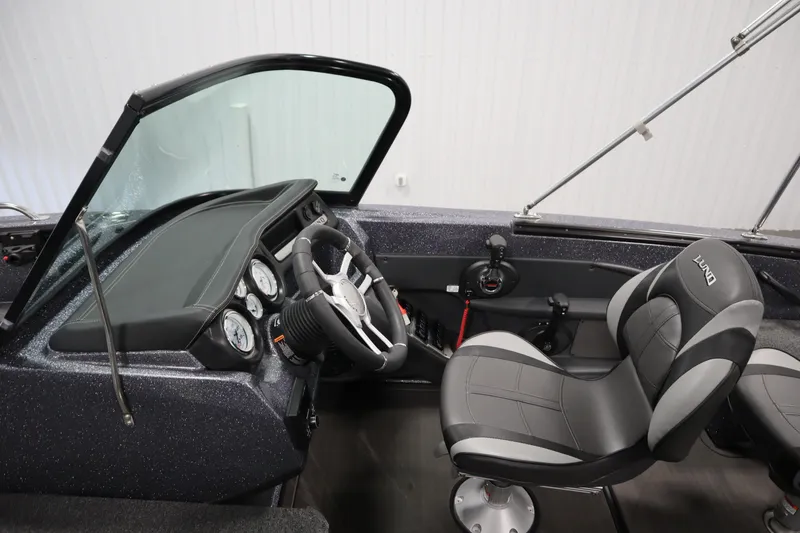 Slide: The Image of 2023 Lund 189 PRO V boat interior with steering wheel and seats, showcasing modern design. - 25
