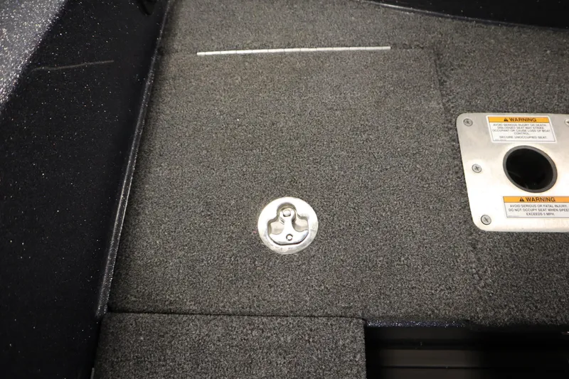 Slide: The Image of 2023 Lund 189 PRO V boat deck with storage compartment and safety warning labels. - 44