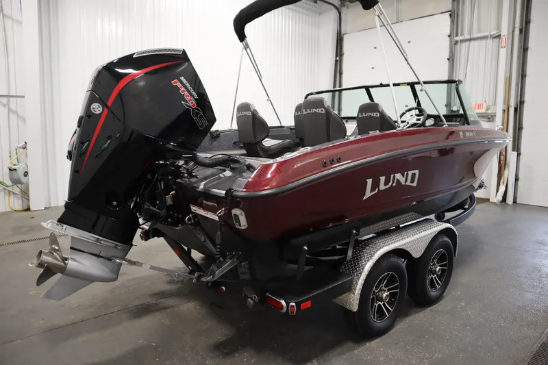 Slide: The Image of 2023 Lund 189 PRO V boat with powerful outboard motor in a garage setting. - 5