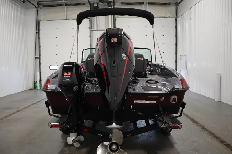 Slide: The Image of 2023 Lund 189 PRO V boat with dual Mercury outboard motors in a garage setting. - 6