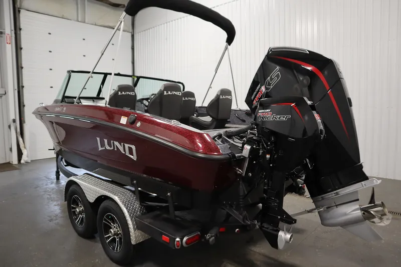 Slide: The Image of 2023 Lund 189 PRO V boat with Mercury Pro Kicker engine in a garage setting. - 7