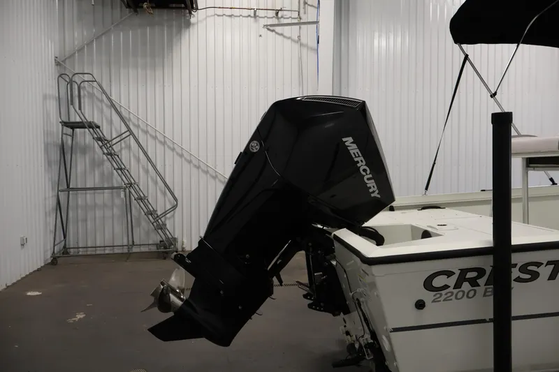Slide: The Image of 2022 Crestliner 2200 Bay boat with Mercury outboard motor in a storage facility. - 43