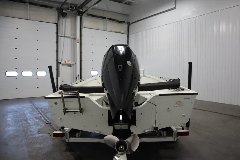 Slide: The Image of 2022 Crestliner 2200 CC boat in a garage, rear view with motor. - 6