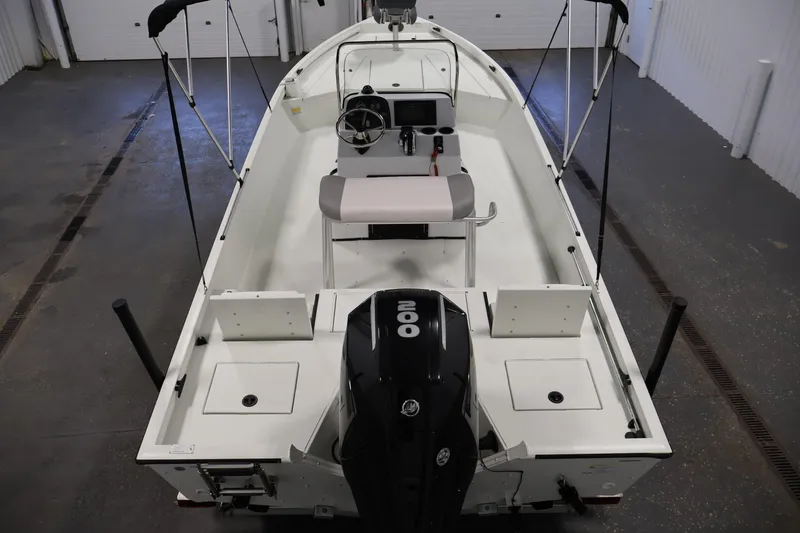 Slide: The Image of 2022 Crestliner 2200 Bay boat with outboard motor in a garage setting. - 11