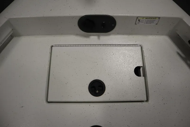 Slide: The Image of 2022 Crestliner 2200 CC boat deck with storage compartment and warning label. - 13