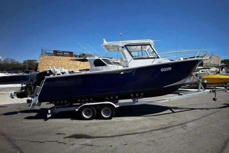 Slide: The Image of 2026 33rd Strike Group FOX-3637 boat on trailer, parked outdoors under clear sky. - 85