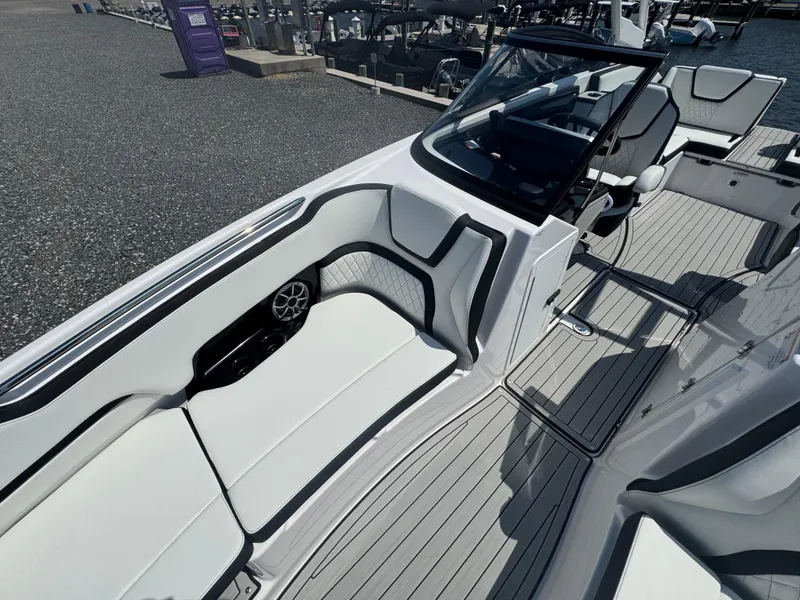 Slide: The Image of 2025 Yamaha Boats 252S interior with sleek seating and modern design at a marina. - 12