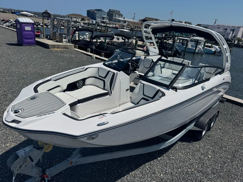 Slide: The Image of 2025 Yamaha Boats 252S, sleek white design, docked at marina, ready for adventure. - 20