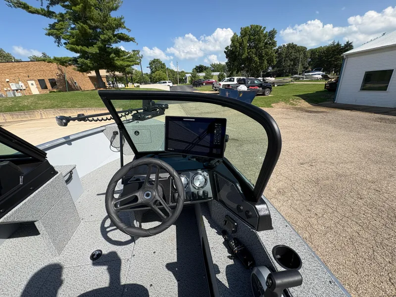 Slide: The Image of 2025 Lund 1875 Alaskan Sport boat dashboard with steering wheel and navigation system. - 16
