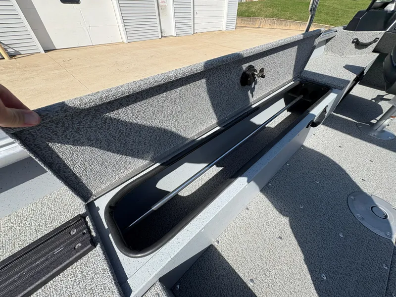 Slide: The Image of 2025 Lund 1875 Alaskan Sport boat storage compartment open, showcasing interior space. - 24