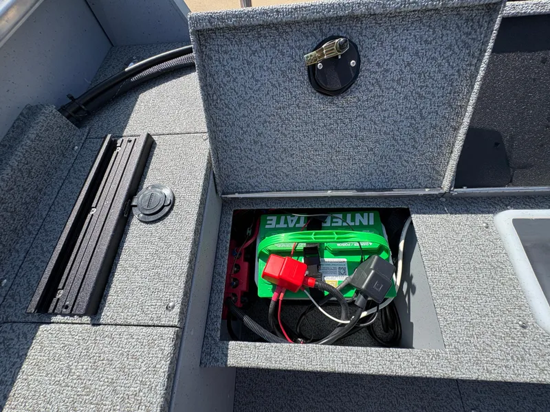 Slide: The Image of 2025 Lund 1875 Alaskan Sport boat battery compartment with green battery and wiring. - 27