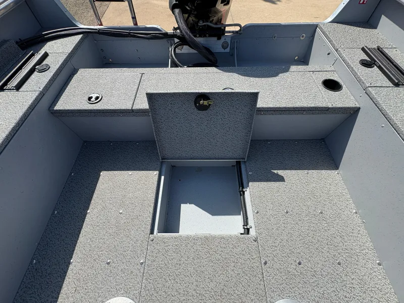 Slide: The Image of 2025 Lund 1875 Alaskan Sport boat interior with storage compartments and textured flooring. - 28
