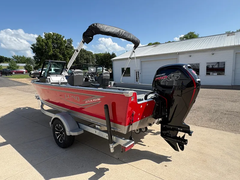 Slide: The Image of 2025 Lund 1875 Alaskan Sport boat with Mercury Pro XS engine, parked outdoors. - 3